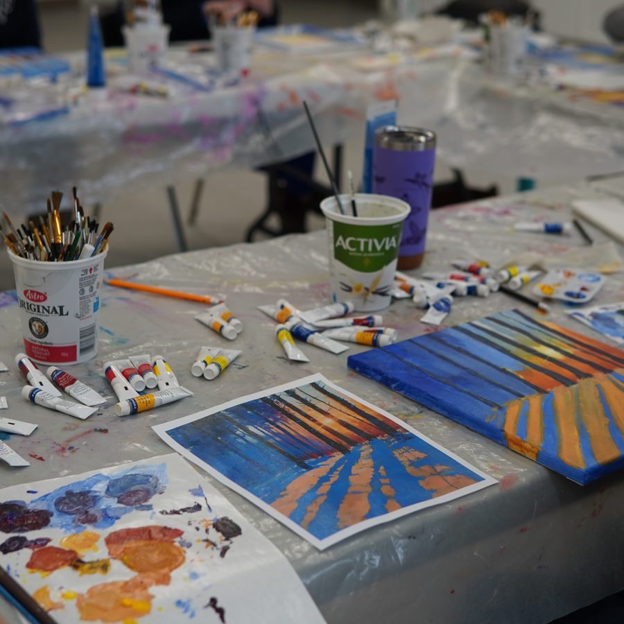 Acrylic painting workshop — a student painting an Ontario sunset forest from a reference